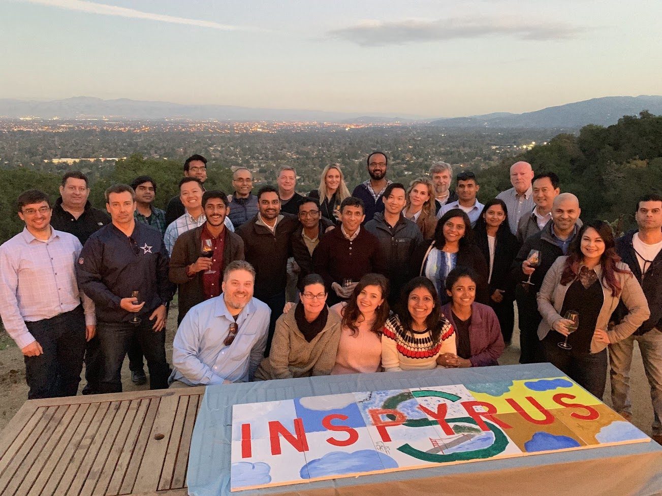 A team proudly displaying the colorful mural they created together