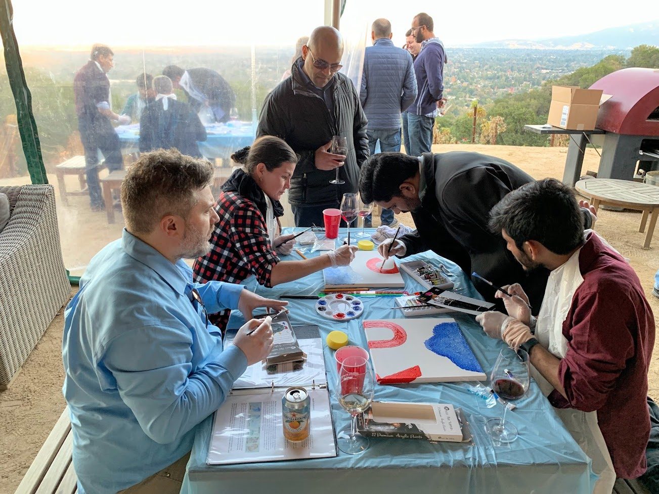 Teammates painting together at an outdoor art station