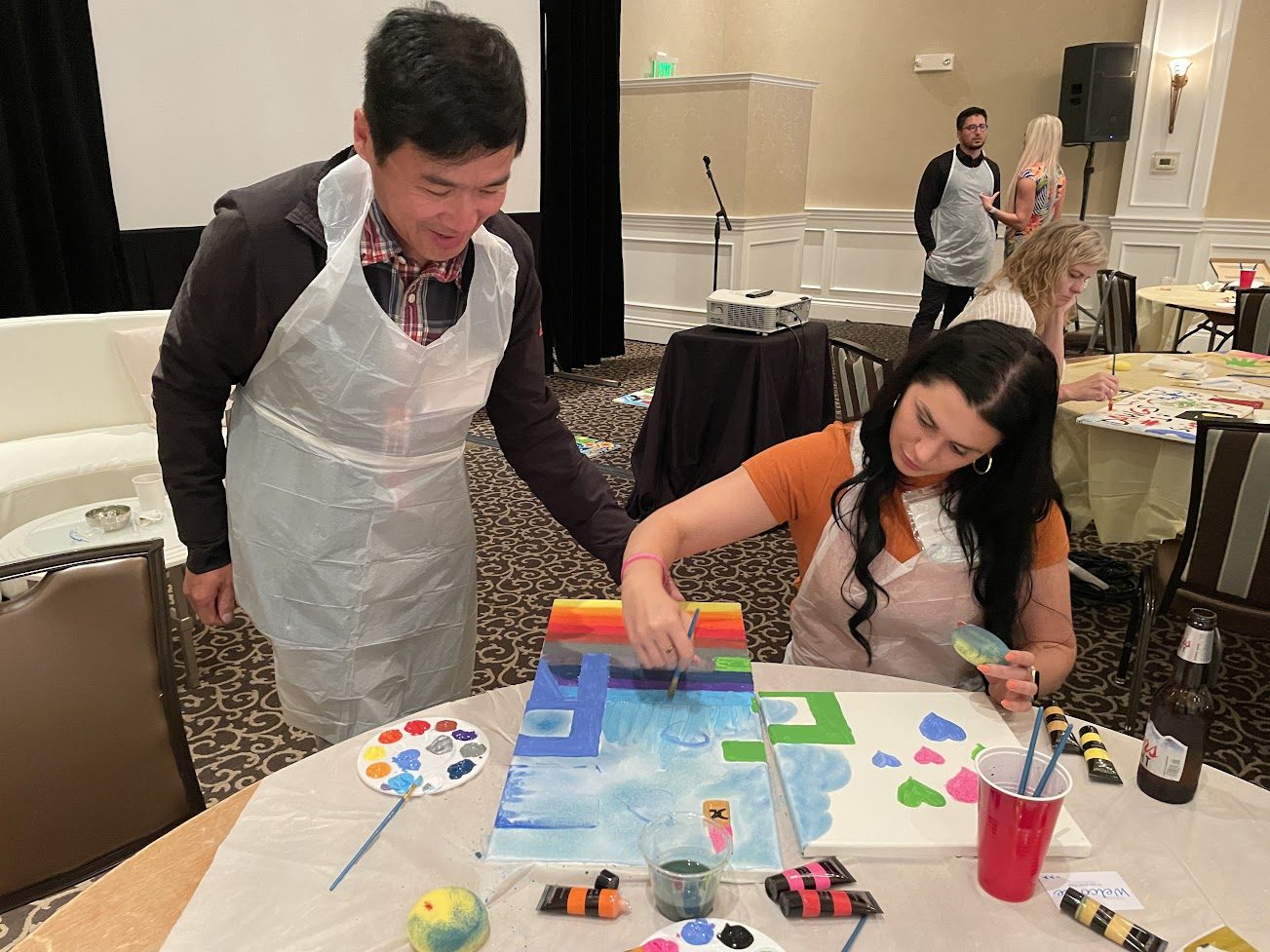 Two colleagues concentrating on their painted panels