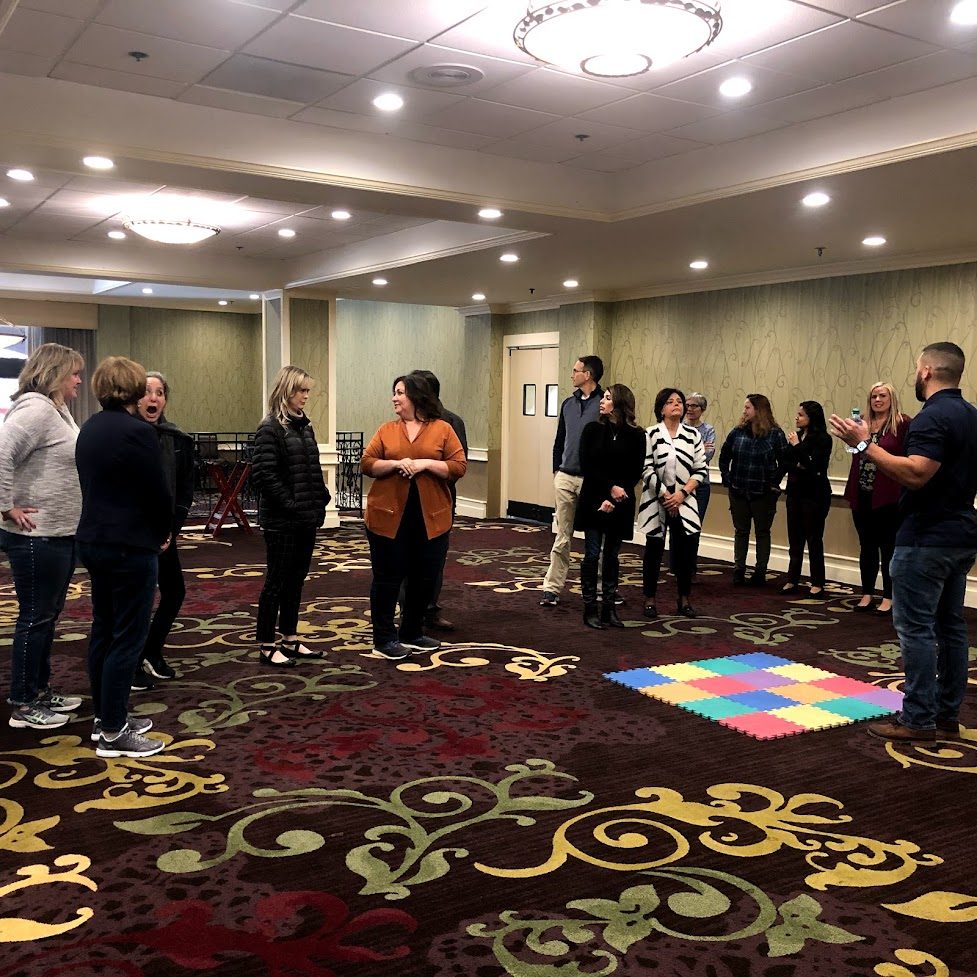The group gathering around the assembled art for the reveal