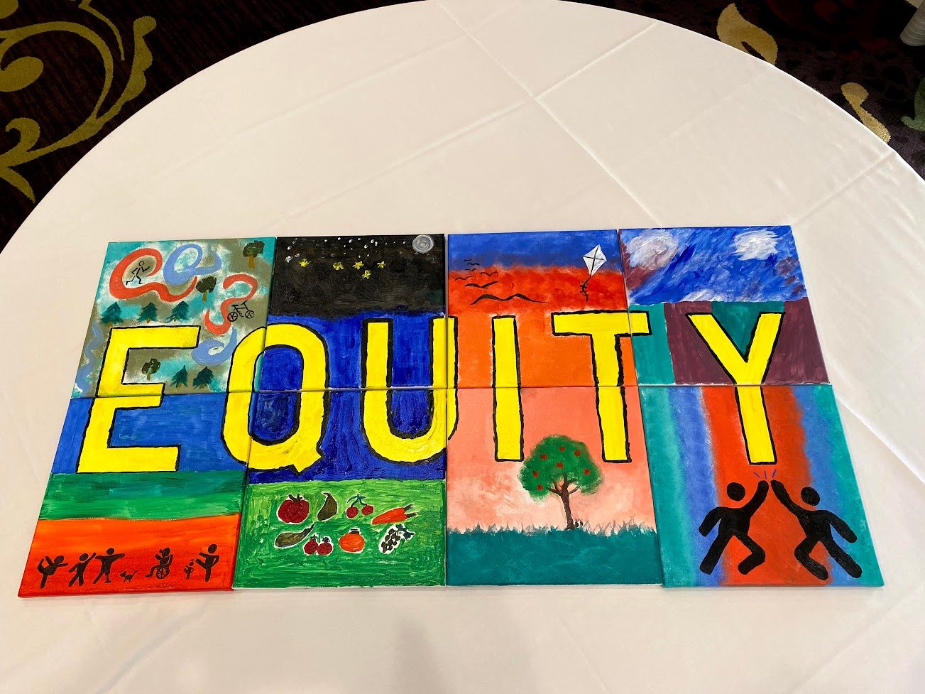 A completed, colorful group mural spelling Equity