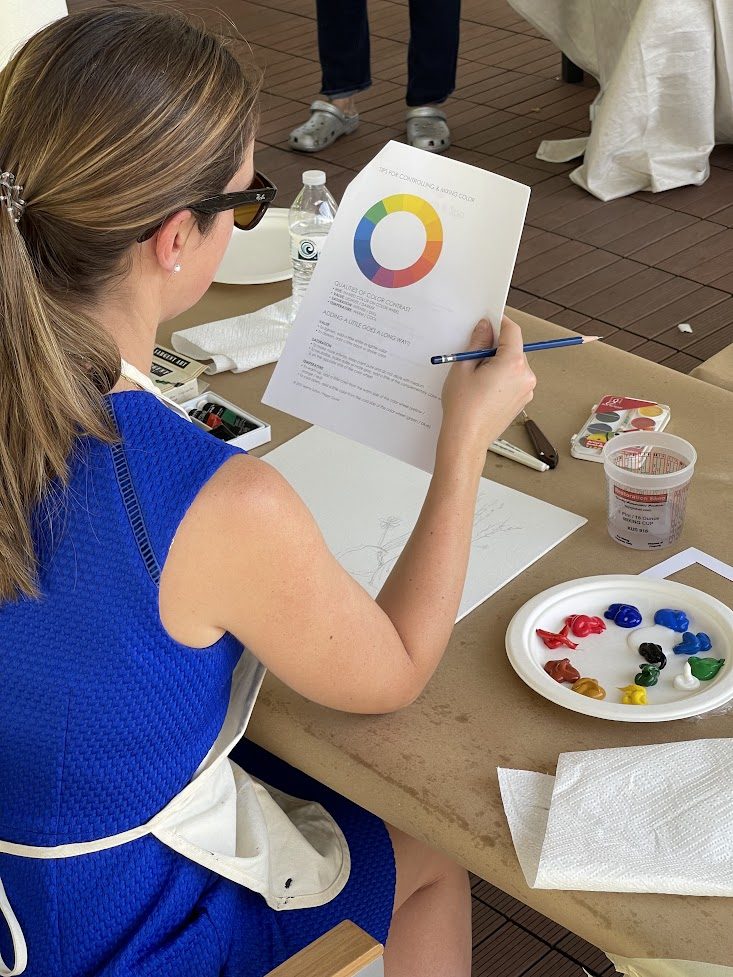 A participant adding paint to a circular artwork